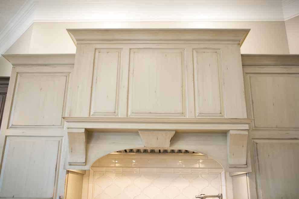 Inspiration for a large transitional u-shaped medium tone wood floor and brown floor kitchen remodel in Indianapolis with a farmhouse sink, raised-panel cabinets, dark wood cabinets, granite countertops, white backsplash, subway tile backsplash, paneled appliances, an island and multicolored countertops