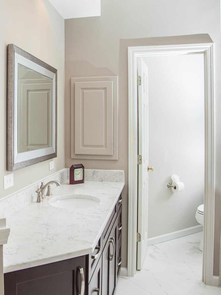 Photo of a large contemporary master bathroom in Atlanta with flat-panel cabinets, dark wood cabinets, a drop-in tub, an open shower, a one-piece toilet, white tile, porcelain tile, beige walls, porcelain floors, an undermount sink, engineered quartz benchtops, white floor and a hinged shower door.