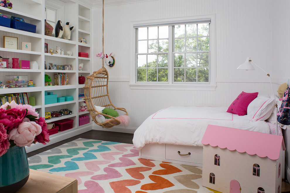 This is an example of a mid-sized transitional kids' bedroom for kids 4-10 years old and girls in San Diego with white walls and dark hardwood floors.
