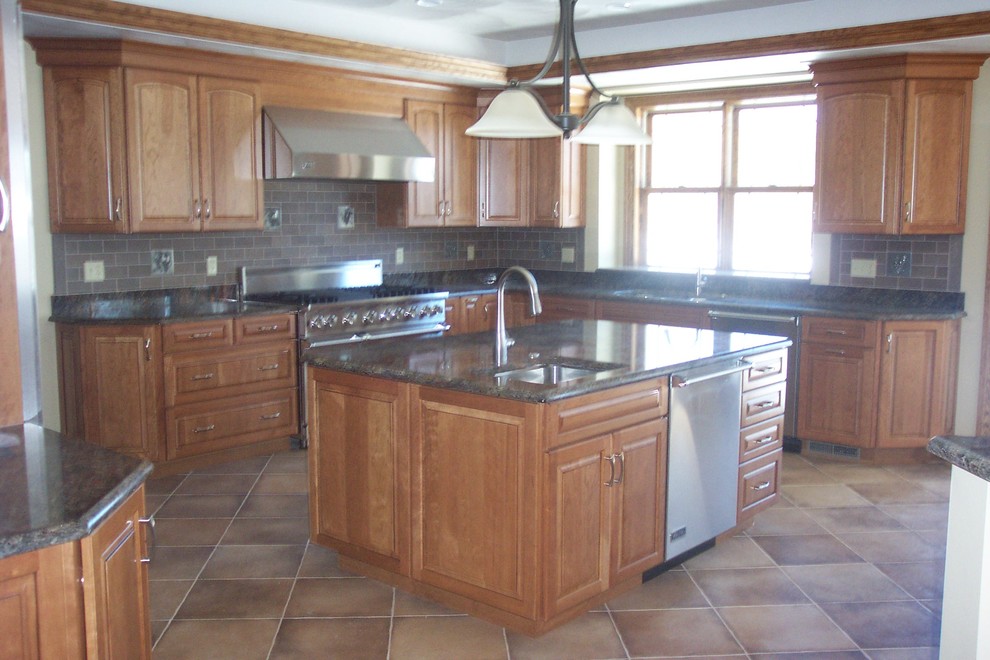 Eat-in kitchen - large l-shaped eat-in kitchen idea with a single-bowl sink, medium tone wood cabinets, brown backsplash, stainless steel appliances and an island