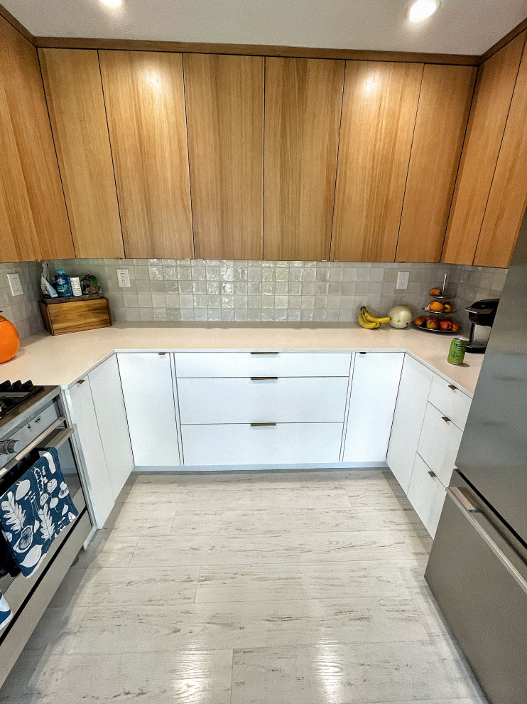 Idéer för att renovera ett avskilt, litet funkis vit vitt u-kök, med en undermonterad diskho, släta luckor, skåp i mellenmörkt trä, bänkskiva i kvarts, grått stänkskydd, stänkskydd i keramik, rostfria vitvaror, ljust trägolv och vitt golv