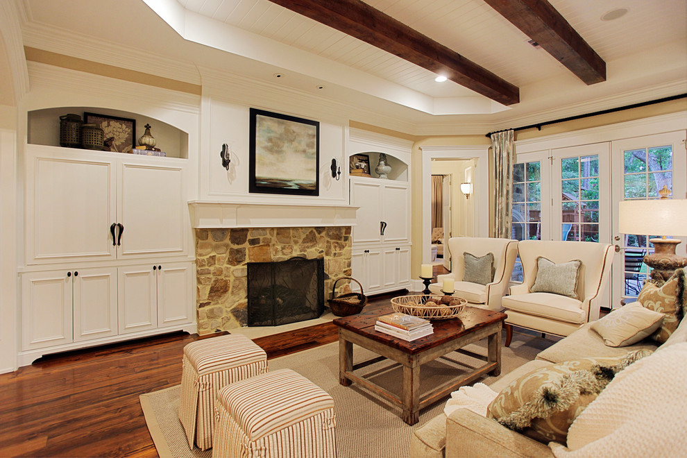 This is an example of a traditional living room in Houston with a stone fireplace surround.