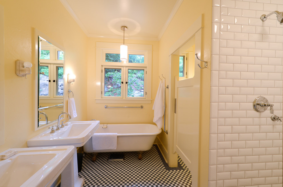 Design ideas for a traditional bathroom in Portland with a claw-foot tub, a pedestal sink, yellow walls and multi-coloured floor.