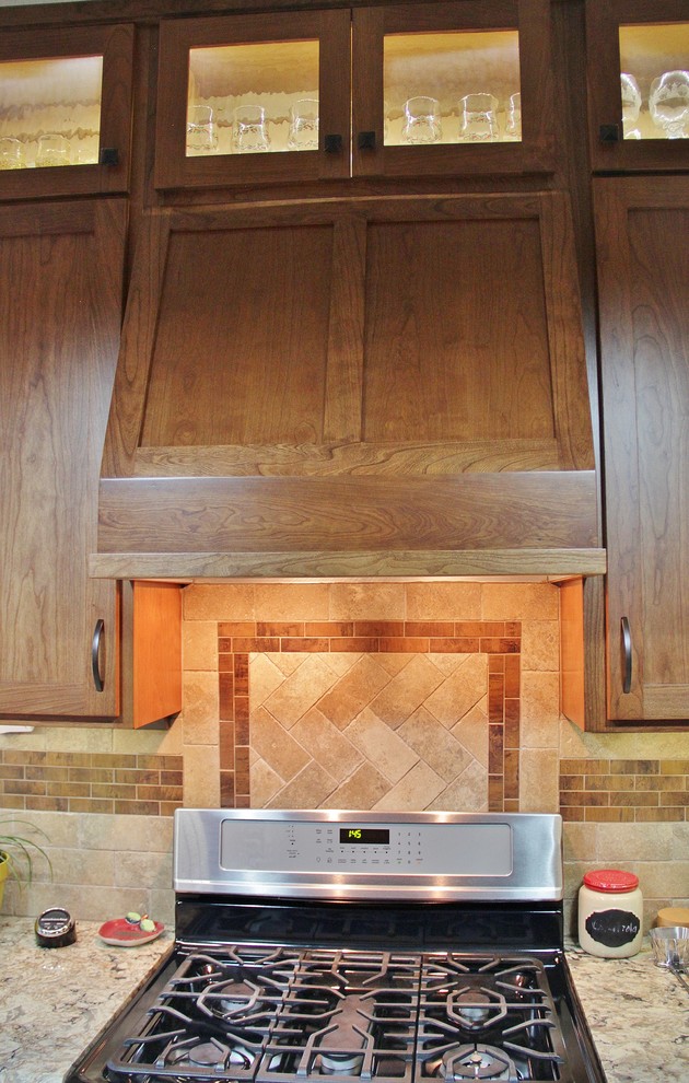 Enclosed kitchen - mid-sized transitional galley ceramic tile enclosed kitchen idea with an undermount sink, shaker cabinets, medium tone wood cabinets, quartz countertops, beige backsplash, stone tile backsplash, stainless steel appliances and a peninsula