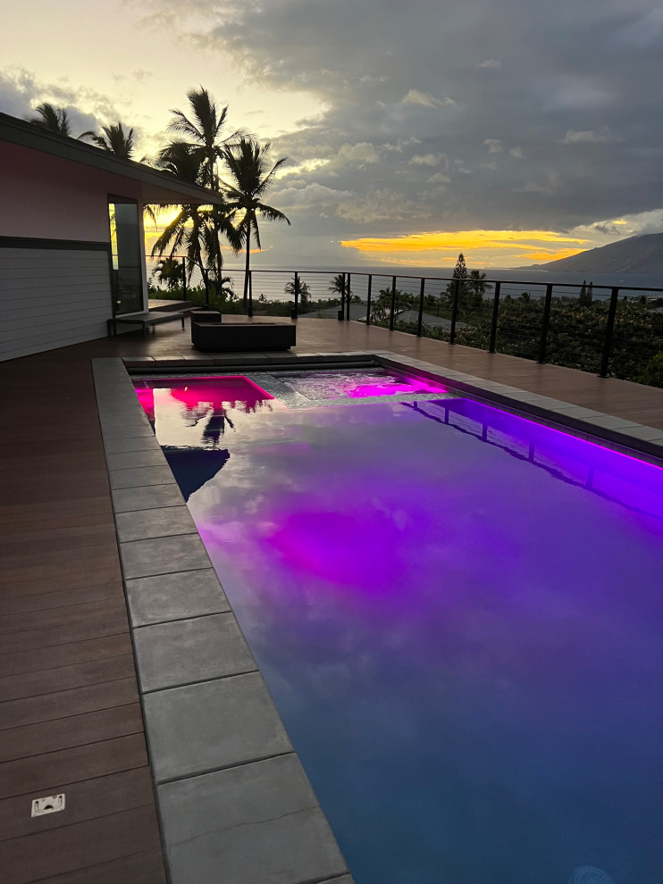Cette photo montre une très grande piscine hors-sol et latérale moderne rectangle avec une terrasse en bois et un bain bouillonnant.