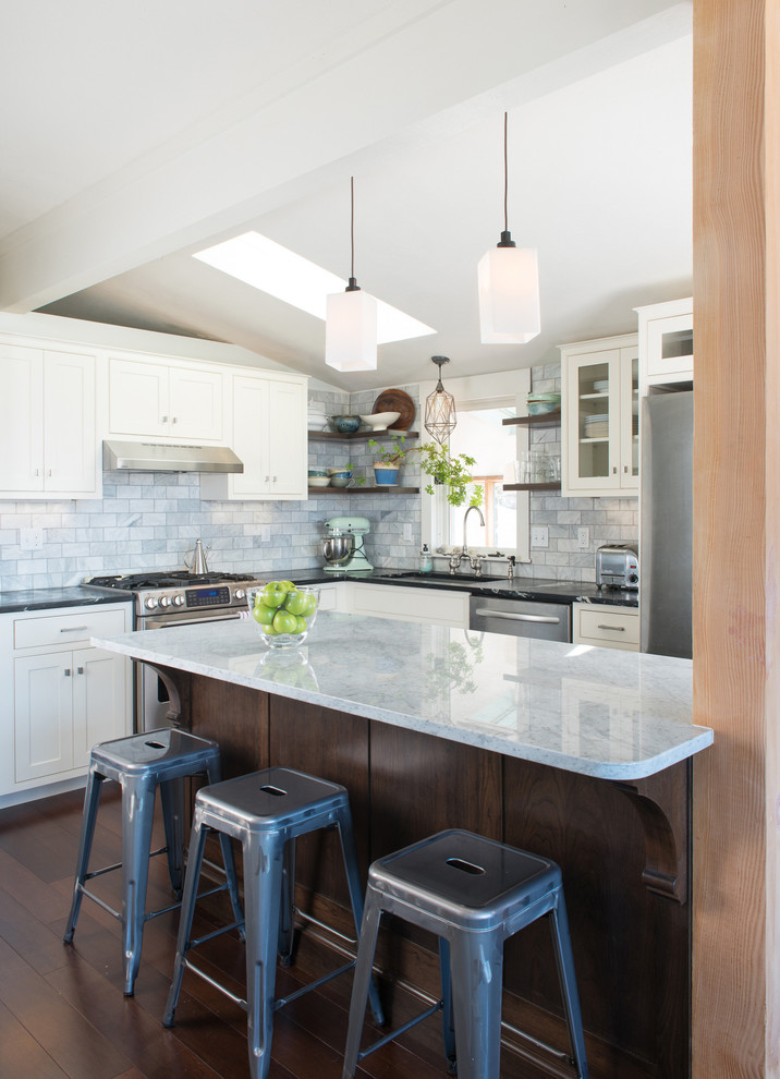 Inspiration for a transitional l-shaped dark wood floor eat-in kitchen remodel in Denver with an undermount sink, recessed-panel cabinets, white cabinets, quartz countertops, gray backsplash, ceramic backsplash, stainless steel appliances and an island