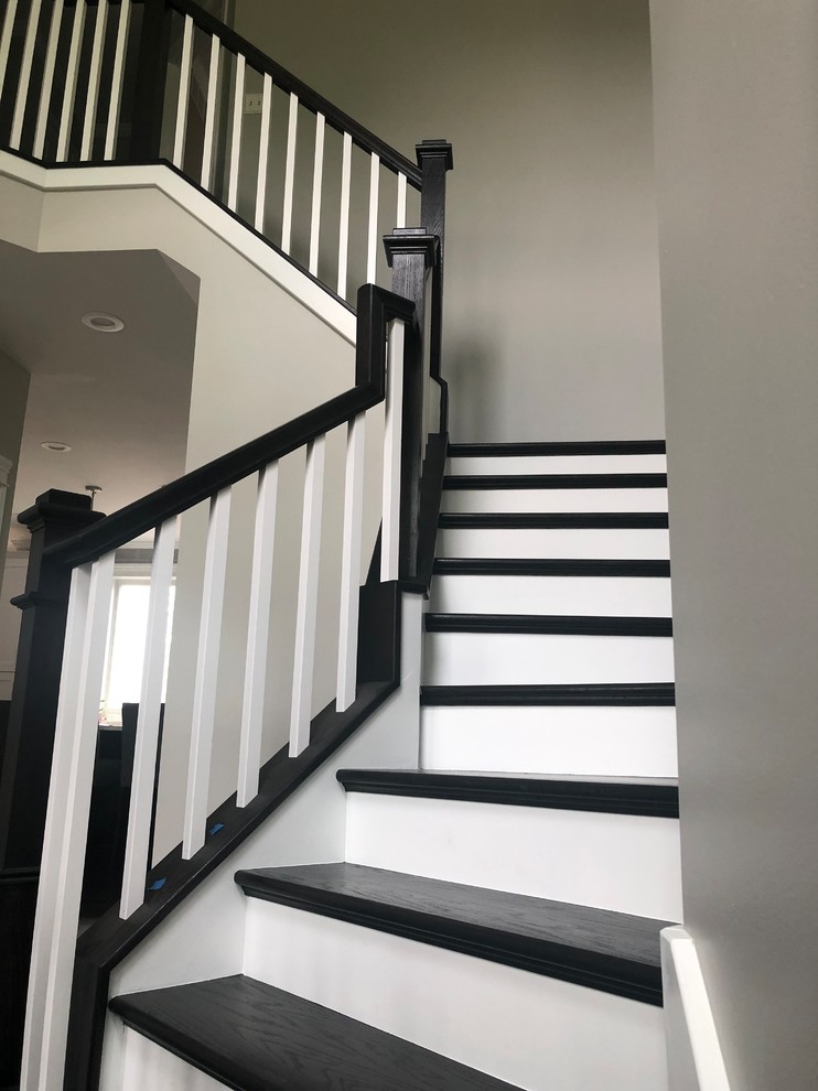 This is an example of a mid-sized transitional wood u-shaped staircase in Chicago with painted wood risers and wood railing.