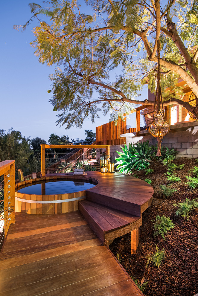 Large contemporary backyard pool in San Diego with decking and a hot tub.