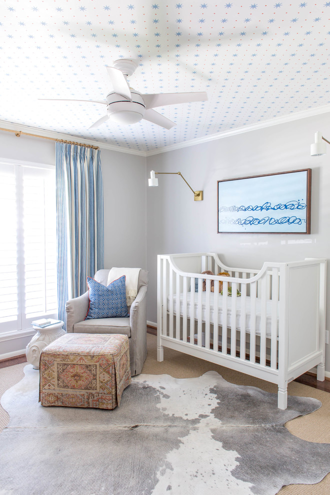 Photo of a mid-sized beach style nursery for boys in Houston with grey walls and dark hardwood floors.
