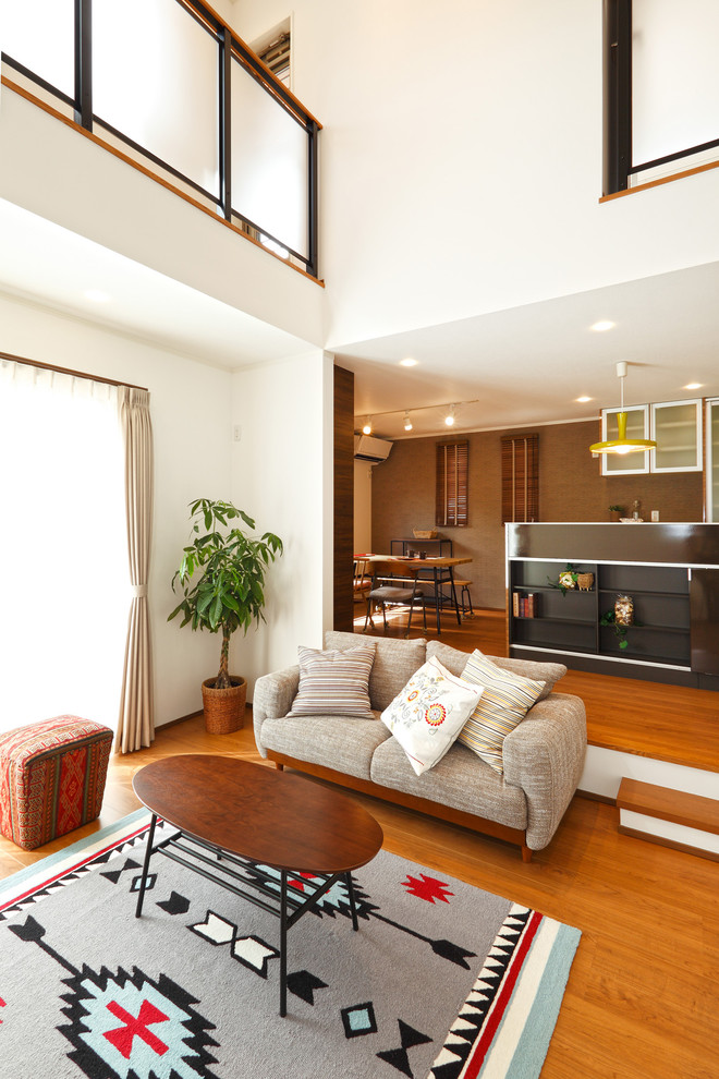 Inspiration for an asian living room in Other with white walls, medium hardwood floors and brown floor.