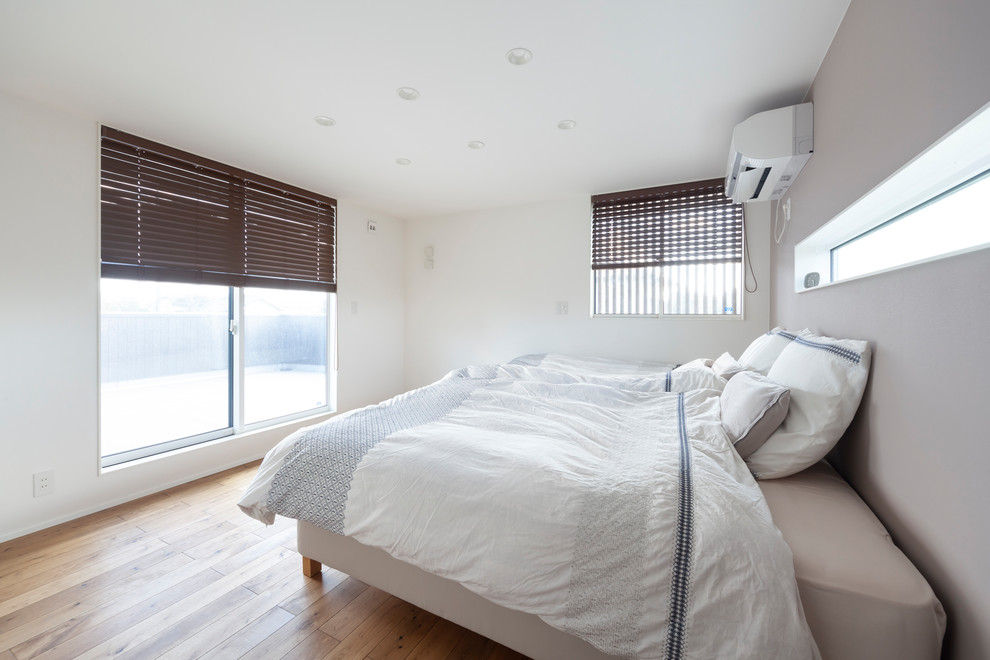 他の地域にある北欧スタイルのおしゃれな寝室 (白い壁、茶色い床、無垢フローリング)