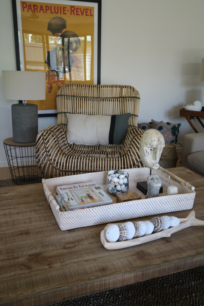 Immagine di un grande soggiorno stile marino chiuso con pareti bianche, parquet chiaro, stufa a legna, TV autoportante e pavimento beige