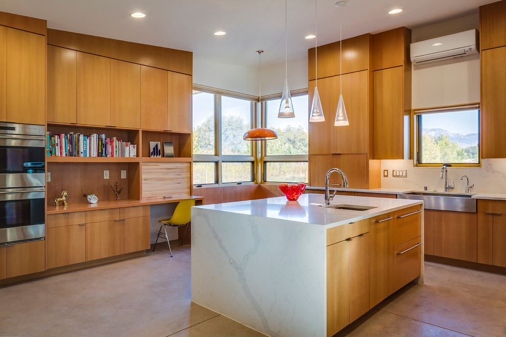 Inspiration for a modern l-shaped kitchen in Albuquerque with a farmhouse sink, flat-panel cabinets, medium wood cabinets, quartz benchtops, white splashback, stainless steel appliances, concrete floors and with island.