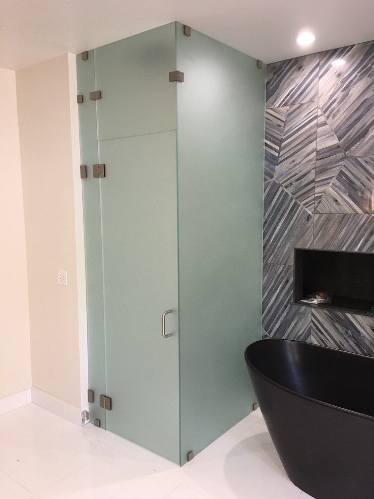Example of a transitional master bathroom design with a hinged shower door