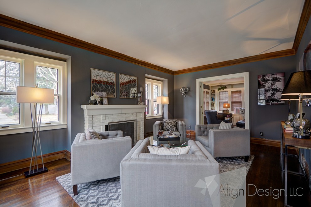 Photo of a large transitional enclosed living room in Grand Rapids with grey walls, medium hardwood floors, a brick fireplace surround and no tv.