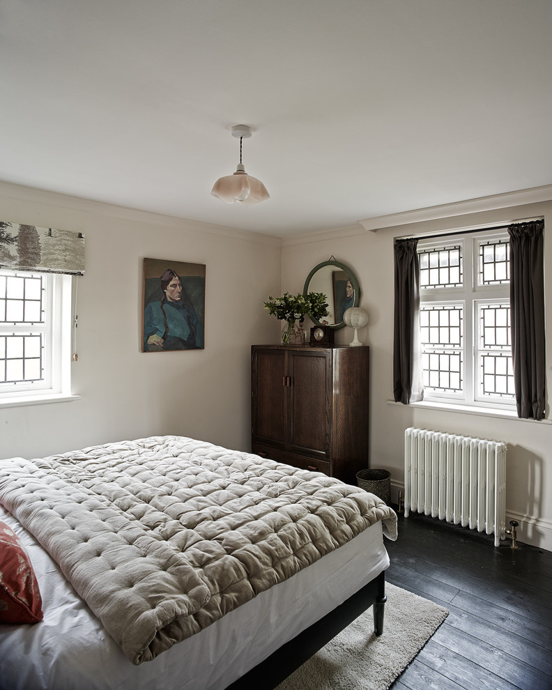 Inspiration for a small country guest bedroom in Sussex with pink walls and black floor.