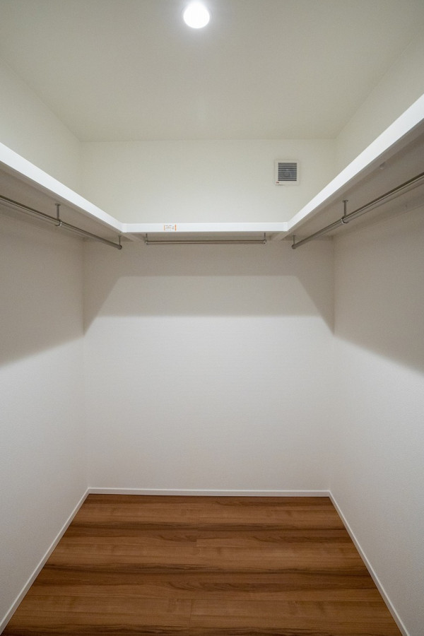 Gender-neutral storage and wardrobe in Kyoto with dark hardwood floors, brown floor and wallpaper.