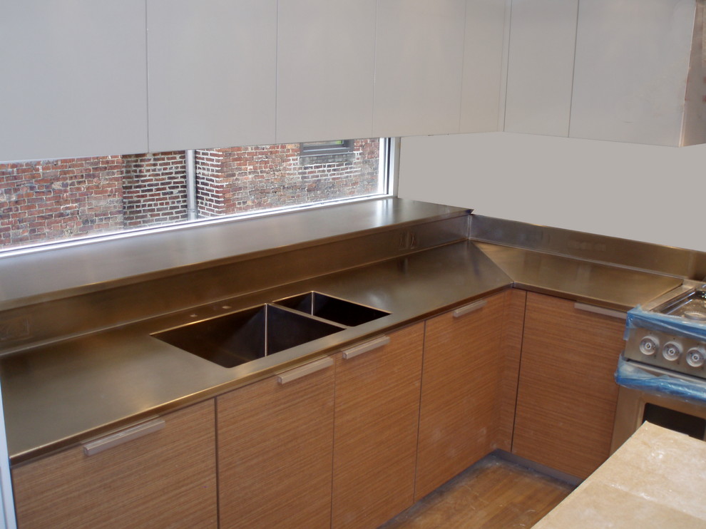 This is an example of a traditional single-wall eat-in kitchen in New York with an integrated sink, light wood cabinets, metal splashback and stainless steel appliances.