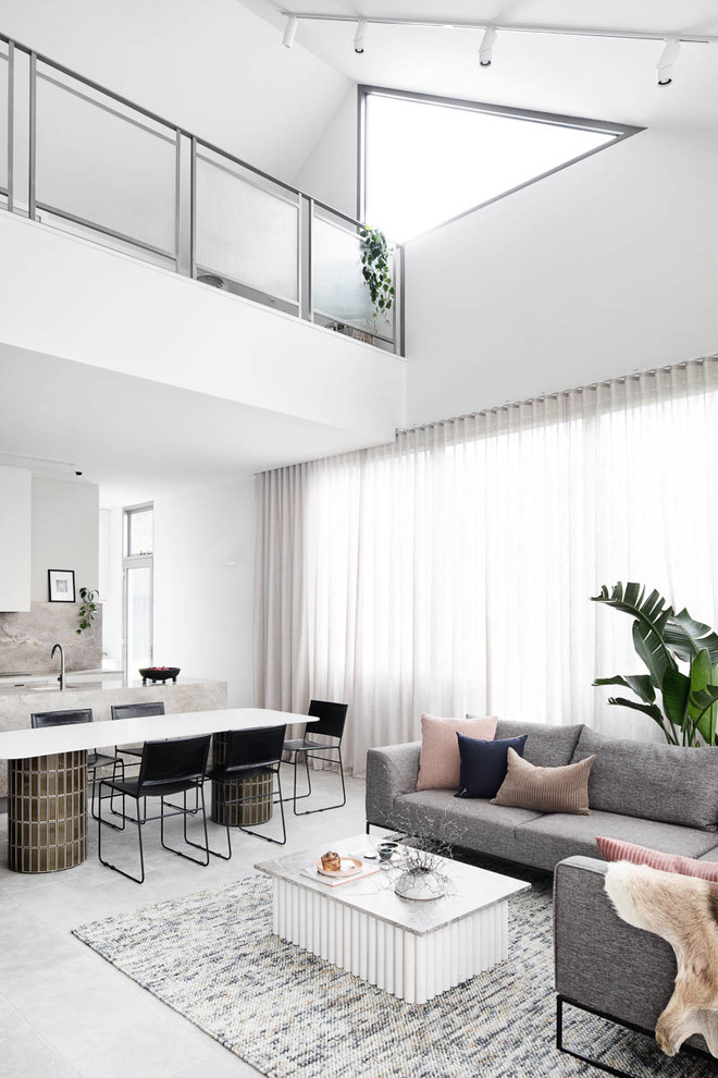 Photo of a large contemporary open concept living room in Melbourne with grey floor and white walls.