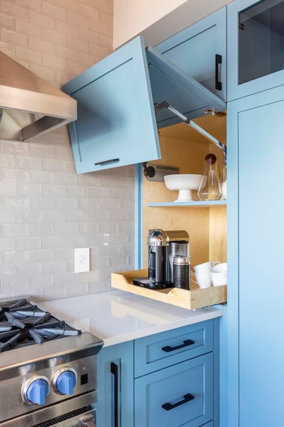 This is an example of a large modern kitchen in Seattle with a farmhouse sink, shaker cabinets, blue cabinets, quartzite benchtops, white splashback, subway tile splashback, stainless steel appliances, slate floors, black floor and white benchtop.