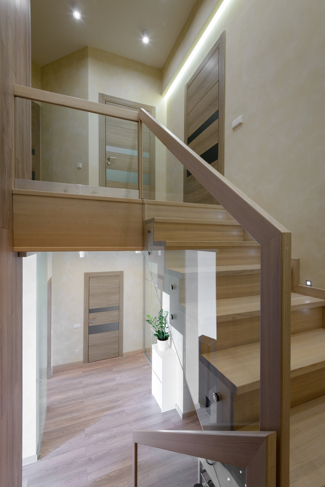 Large contemporary wood u-shaped staircase in Novosibirsk with wood risers.