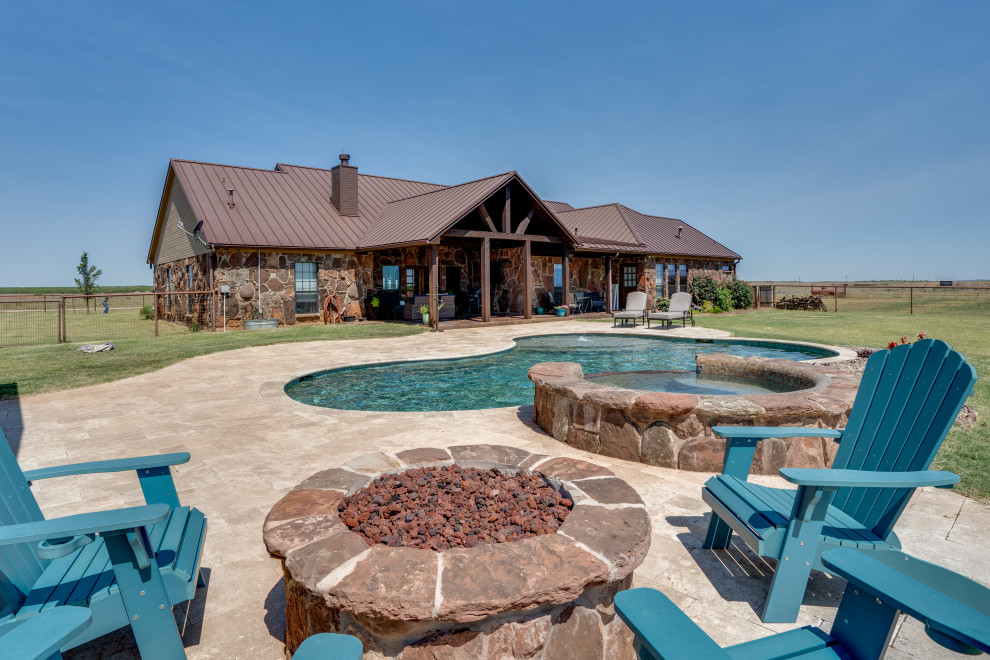 Hot tub - mid-sized rustic backyard stone and custom-shaped hot tub idea in Austin