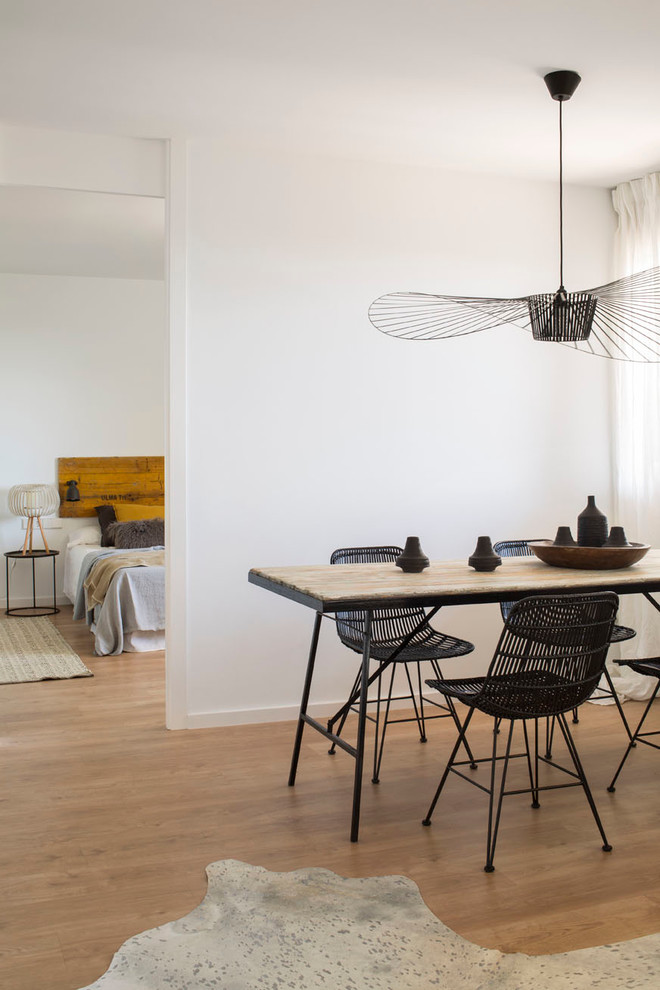 Modelo de comedor actual de tamaño medio con paredes blancas y suelo de madera en tonos medios