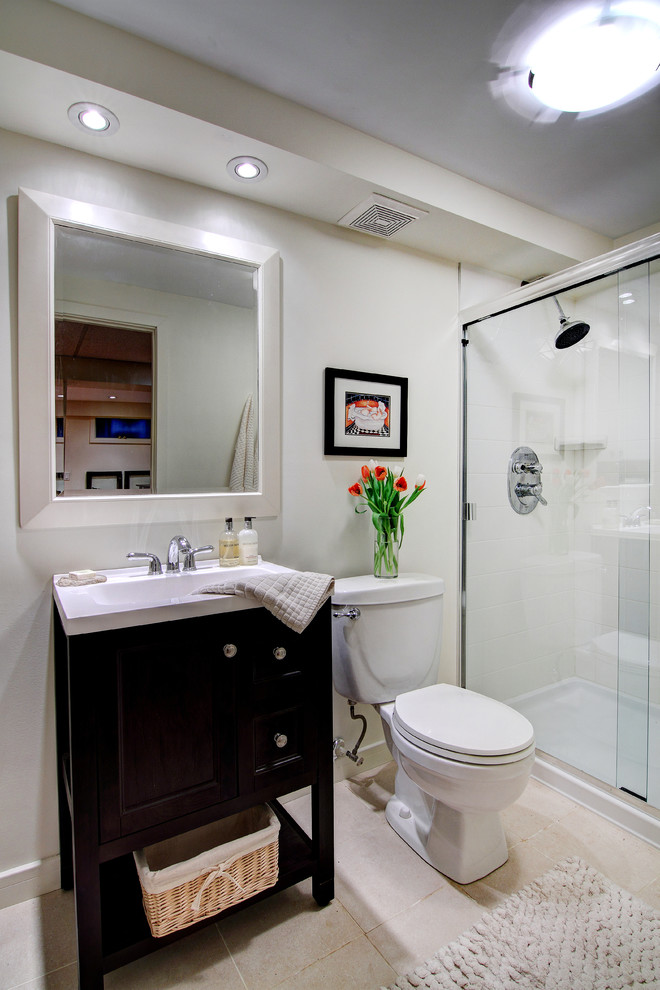 Mid-sized traditional kids bathroom in Calgary with an integrated sink, recessed-panel cabinets, dark wood cabinets, engineered quartz benchtops, an alcove shower, a two-piece toilet, white tile, porcelain tile, white walls and porcelain floors.