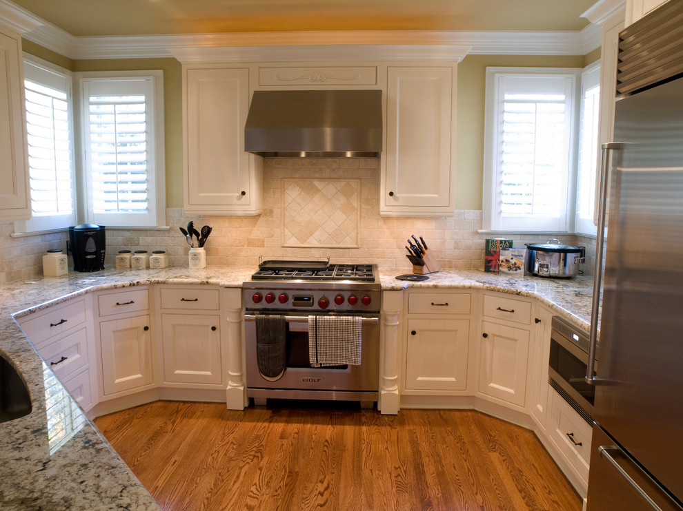 Design ideas for a traditional u-shaped eat-in kitchen in Raleigh with an undermount sink, recessed-panel cabinets, white cabinets, granite benchtops, white splashback, subway tile splashback and stainless steel appliances.