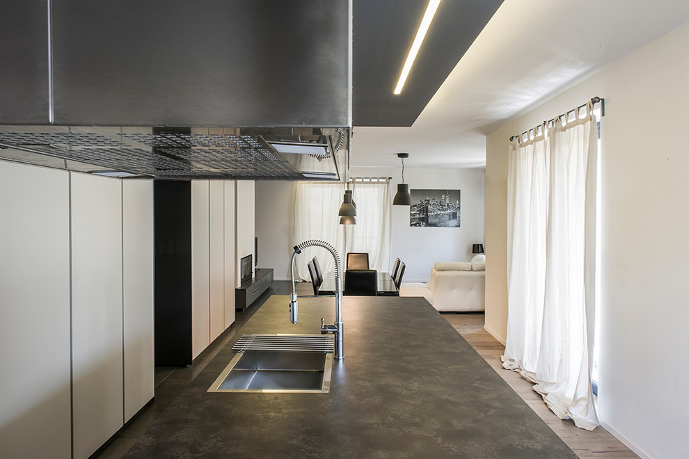 Idee per un grande cucina con isola centrale minimal con pavimento in ardesia e pavimento nero