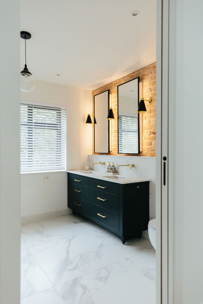 Пример оригинального дизайна: главная ванная комната среднего размера в стиле неоклассика (современная классика) с плоскими фасадами, синими фасадами, открытым душем, инсталляцией, белой плиткой, мраморной плиткой, белыми стенами, мраморным полом, накладной раковиной, мраморной столешницей, белой столешницей, акцентной стеной, встроенной тумбой и кирпичными стенами