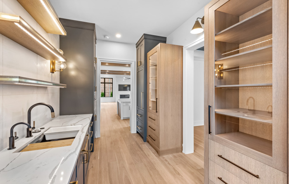Kitchen - large transitional u-shaped light wood floor, brown floor and exposed beam kitchen idea in Chicago with an undermount sink, flat-panel cabinets, white cabinets, quartz countertops, white backsplash, quartz backsplash, paneled appliances, an island and white countertops