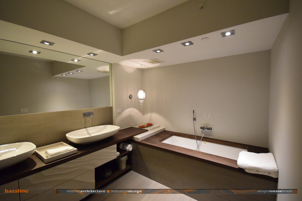 Inspiration for a mid-sized contemporary master bathroom in Miami with furniture-like cabinets, beige cabinets, an undermount tub, a curbless shower, a one-piece toilet, gray tile, porcelain tile, grey walls, porcelain floors, a vessel sink and wood benchtops.