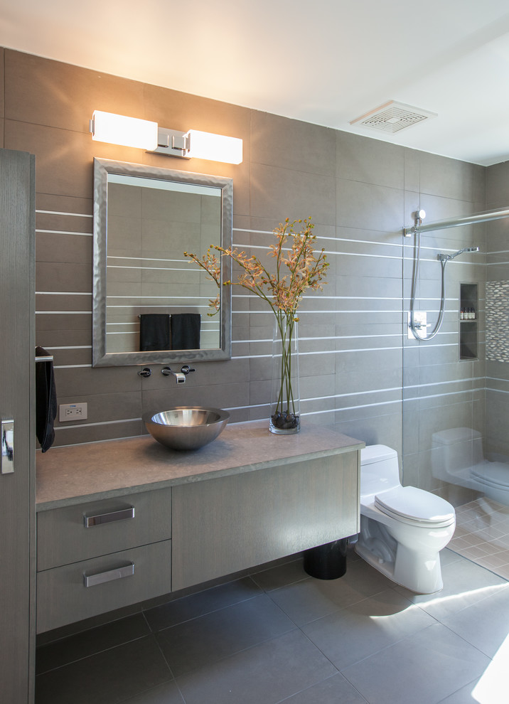 Inspiration for a mid-sized contemporary bathroom in Dallas with a vessel sink, flat-panel cabinets, grey cabinets, limestone benchtops, an open shower, a one-piece toilet, gray tile, porcelain tile, grey walls and porcelain floors.