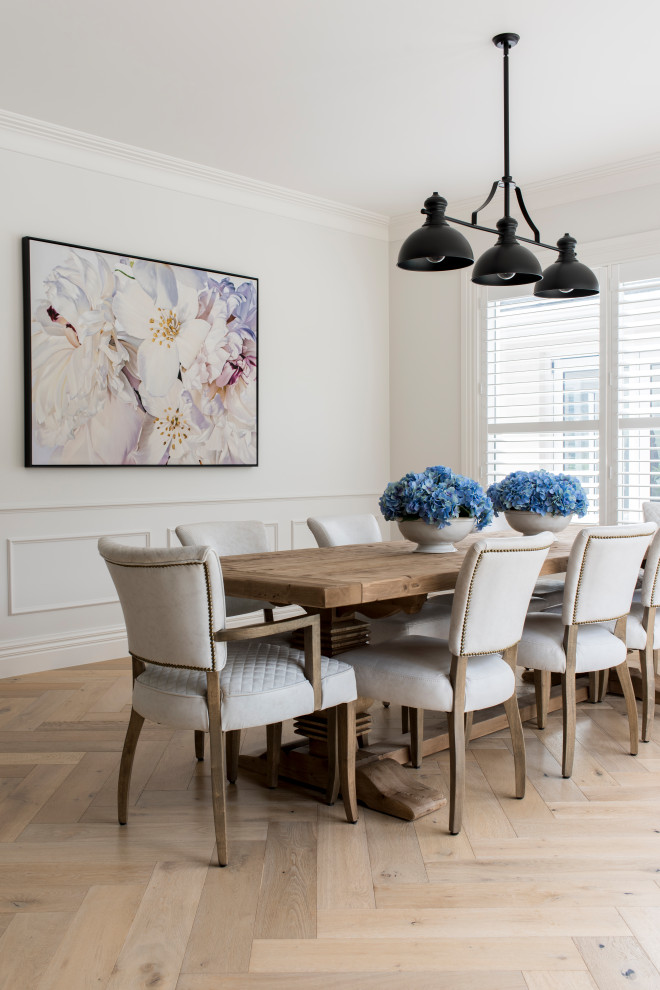 Esempio di una sala da pranzo costiera con pareti bianche, parquet chiaro, pavimento beige e boiserie