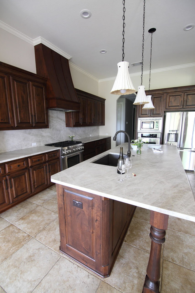 Large transitional l-shaped ceramic tile and beige floor enclosed kitchen photo with an undermount sink, dark wood cabinets, beige backsplash, stainless steel appliances and an island