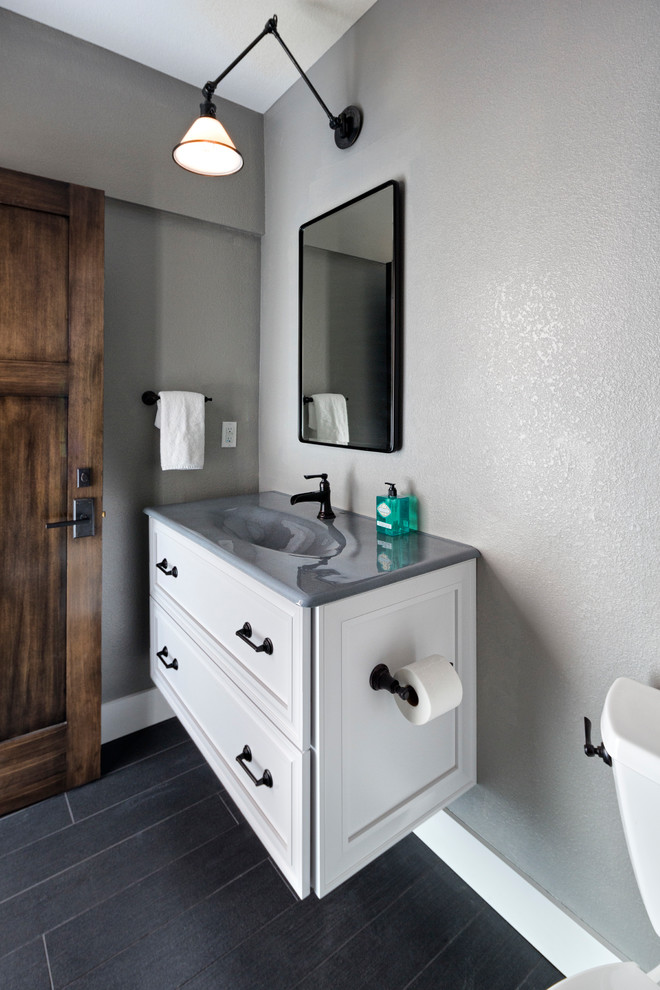 Example of a mid-sized transitional porcelain tile and gray floor bathroom design in Denver with recessed-panel cabinets, white cabinets, a two-piece toilet, gray walls and an integrated sink