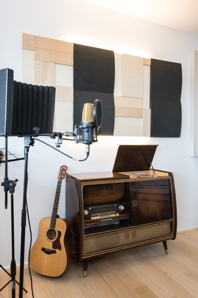 Foto di un atelier minimalista con pareti grigie e parquet chiaro