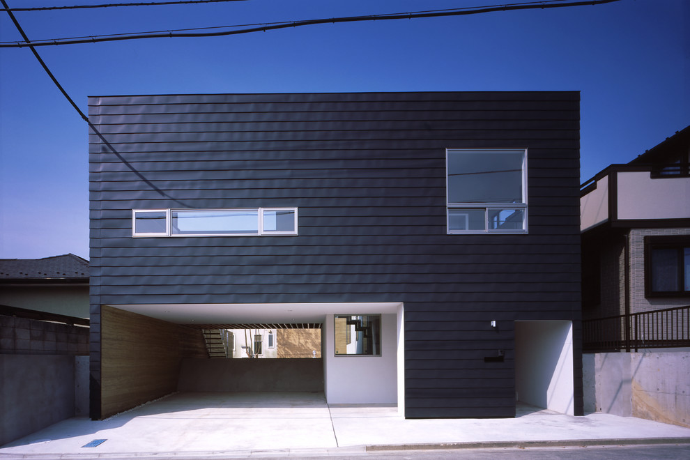 This is an example of a mid-sized modern split-level black house exterior in Tokyo Suburbs with a flat roof, metal siding and a mixed roof.