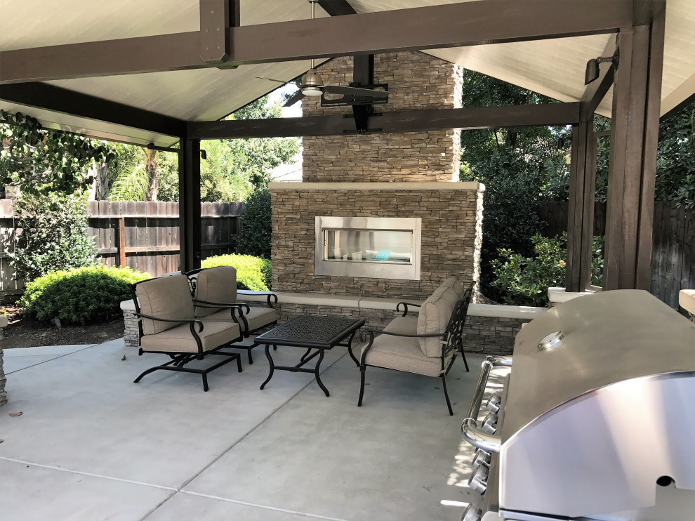 Mid-sized arts and crafts backyard patio in Other with with fireplace, concrete slab and a pergola.