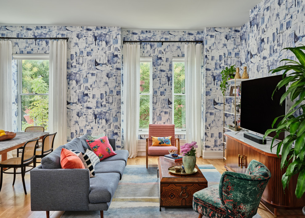 Imagen de salón abierto contemporáneo con paredes multicolor, suelo de madera en tonos medios, televisor independiente, suelo marrón y papel pintado