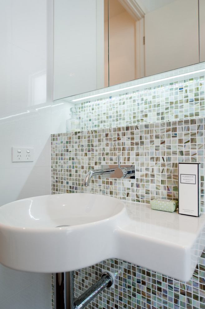Design ideas for a small contemporary bathroom in Adelaide with a wall-mount sink, glass-front cabinets, an alcove shower, a one-piece toilet, multi-coloured tile, mosaic tile, white walls and porcelain floors.