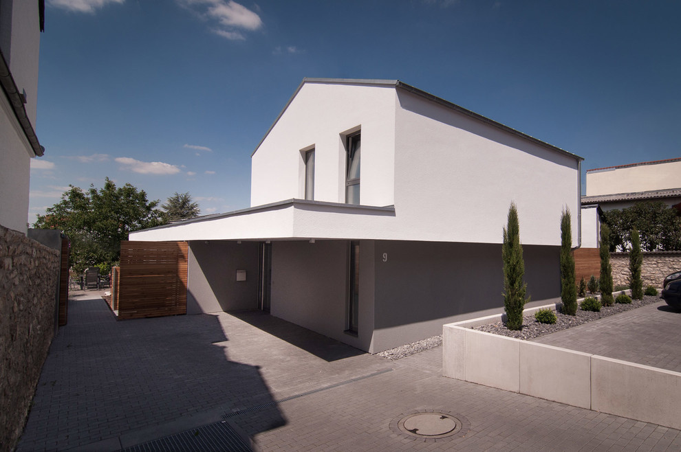 This is an example of a mid-sized contemporary two-storey stucco white exterior in Other with a gable roof.