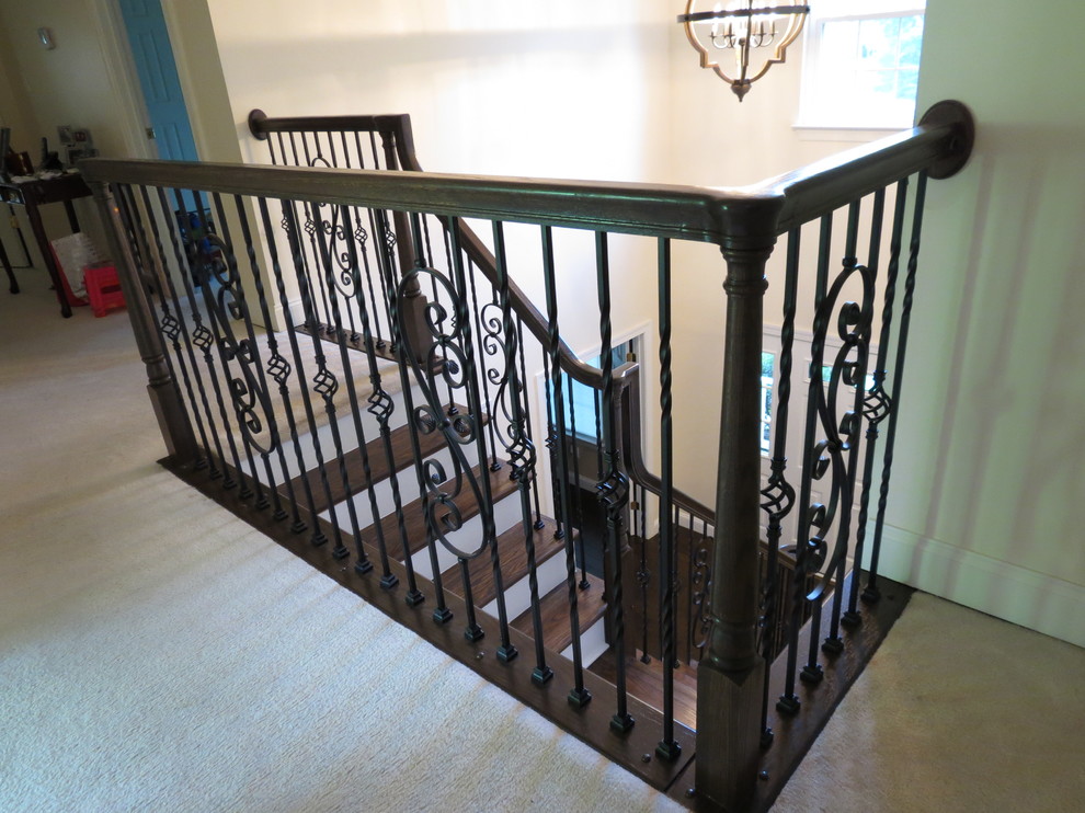 Large transitional galley dark wood floor and brown floor staircase photo with a double-bowl sink, raised-panel cabinets, white cabinets, granite countertops, white backsplash, porcelain backsplash, stainless steel appliances and an island