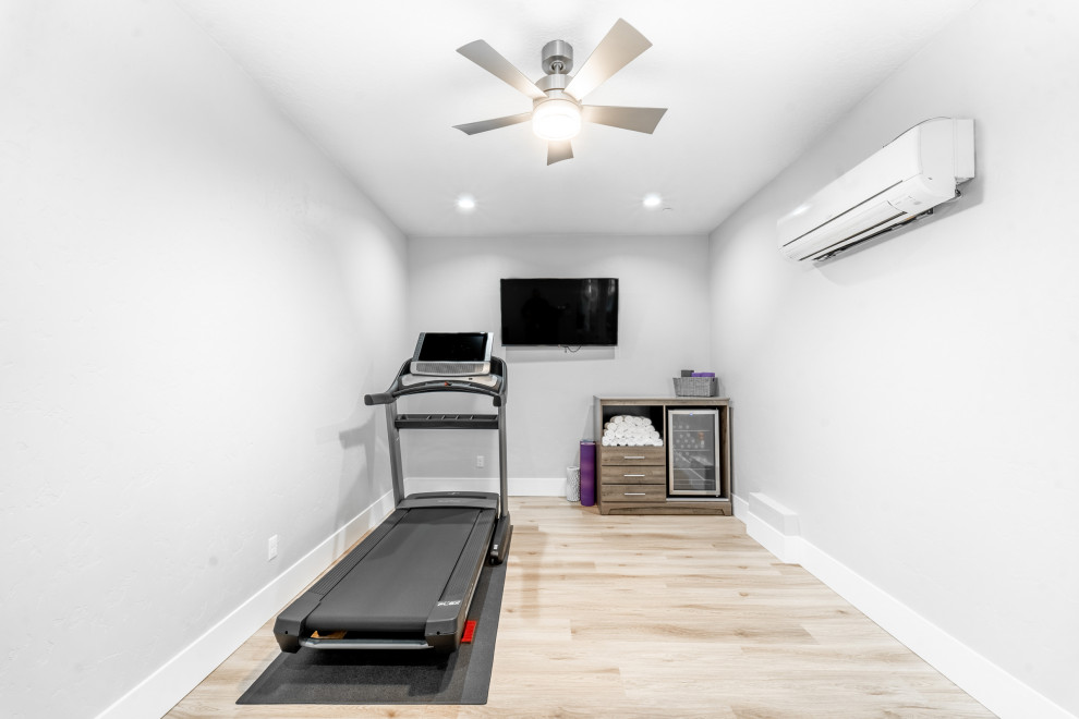 Photo of a mid-sized modern home gym in Boise with laminate floors.
