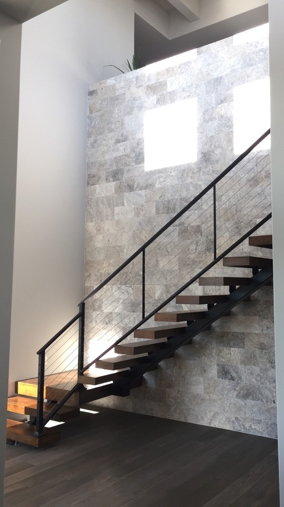 Design ideas for a contemporary wood floating staircase in Austin with metal risers.