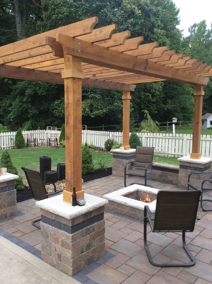 This is an example of a mid-sized traditional backyard patio in Columbus with a fire feature, concrete pavers and a pergola.