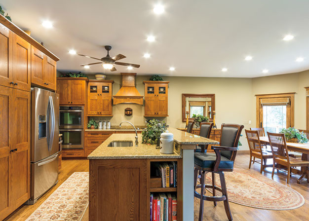Photo of a mid-sized traditional l-shaped eat-in kitchen in Chicago with an undermount sink, shaker cabinets, medium wood cabinets, granite benchtops, stainless steel appliances, medium hardwood floors and with island.