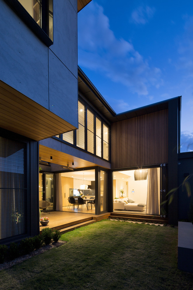 Design ideas for a mid-sized contemporary two-storey concrete house exterior in Sydney with a metal roof.