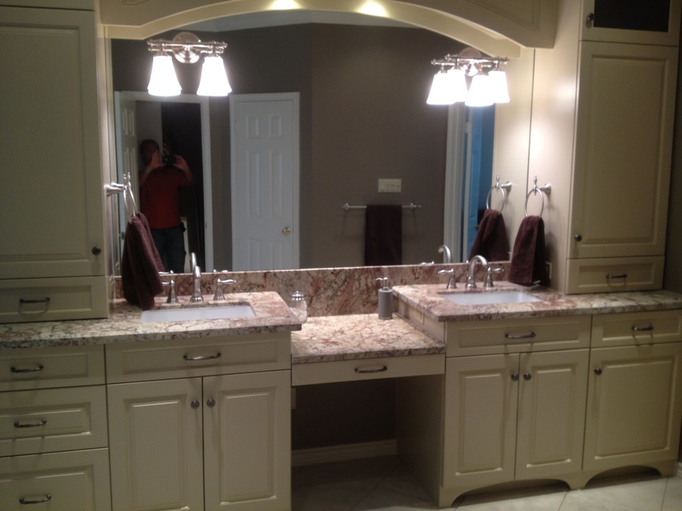 Large transitional master beige tile, brown tile and stone slab corner shower photo in Houston with raised-panel cabinets, white cabinets, a two-piece toilet, beige walls, an undermount sink and granite countertops